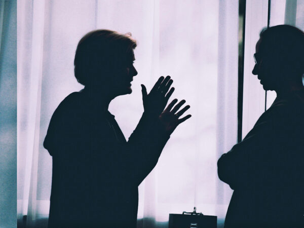 Die Silhouetten zweier Frauen, die unterschiedliche Körperhaltungen eingenommen haben und verschiedene Gesten machen.