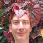 Portraitfoto von Jürgen Brandner, umringt von Zimmerpflanzen